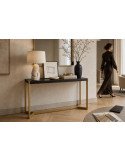 Console chic en métal doré et bois noir dans un salon, lampe et objets posés dessus