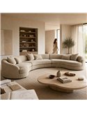 Canapé d'angle arrondi en tissu beige dans un salon épuré avec table basse