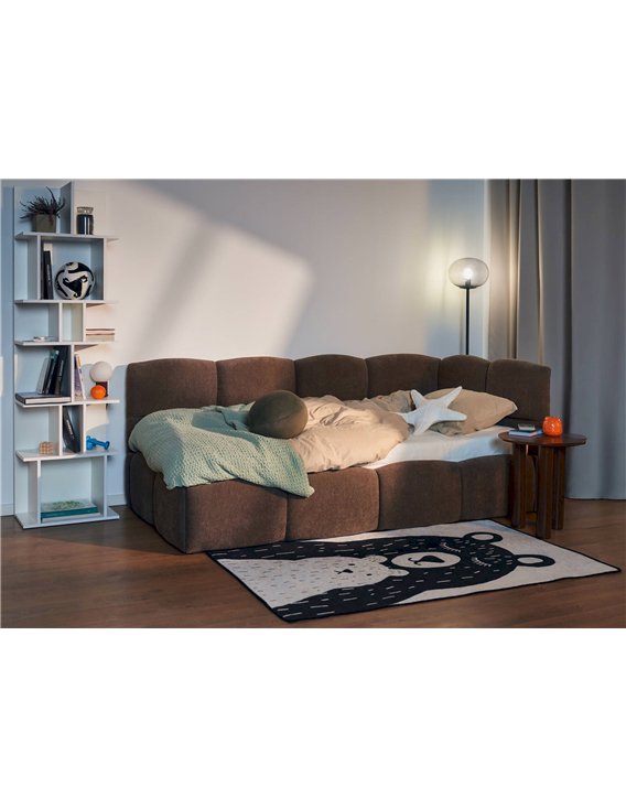 Bibliothèque ouverte blanche dans une chambre, à côté d'un lit en tissu brun