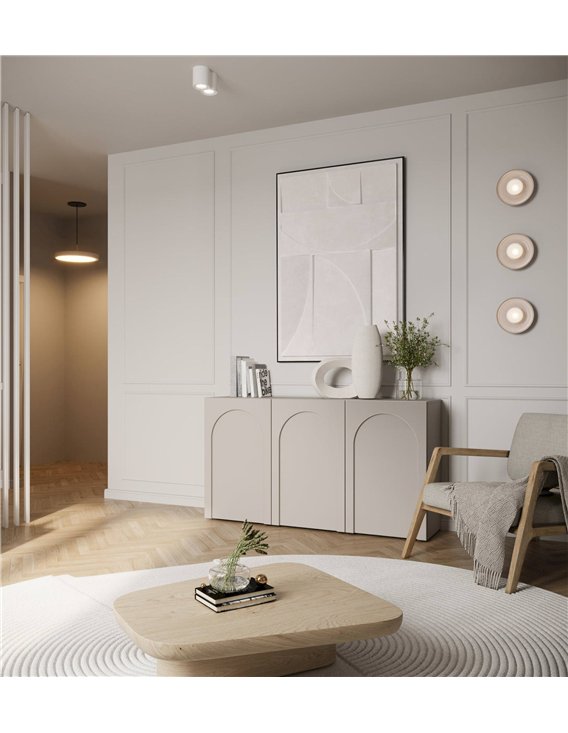 Buffet trois portes arquées beige dans un salon, fauteuil et tapis au sol