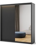 Armoire coulissante noire à portes cannelées et miroir, vue de trois quarts éclairée