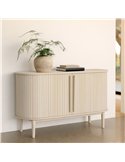 Commode ovale bois clair dans une pièce, plante et livres posés dessus