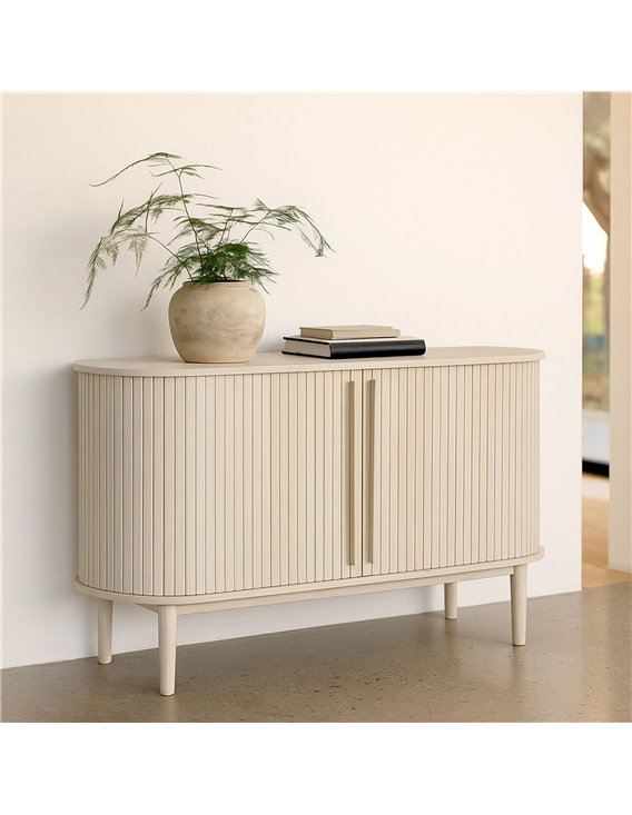 Commode ovale bois clair dans une pièce, plante et livres posés dessus
