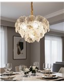 Suspension fleur en verre glamour éclairée au-dessus d'une table de salle à manger dressée