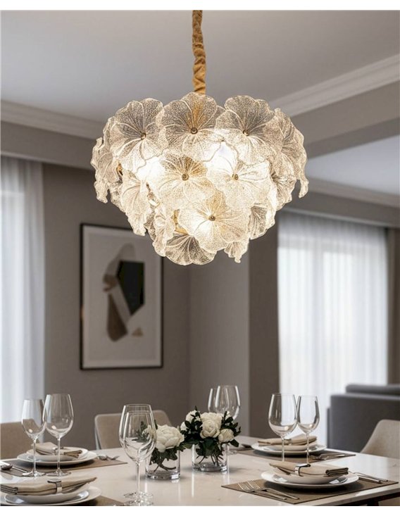 Suspension fleur en verre glamour éclairée au-dessus d'une table de salle à manger dressée