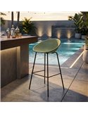 Tabouret de bar ajouré vert sauge près d'un bar extérieur au bord de l'eau
