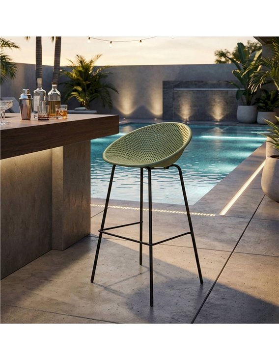 Tabouret de bar ajouré vert sauge près d'un bar extérieur au bord de l'eau