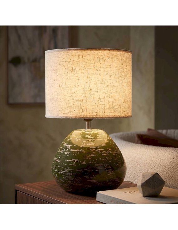 Lampe à poser verte posée sur une table en bois, ambiance salon cosy