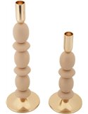 Bougeoirs sculptural beige posés sur un plateau miroir devant une toile