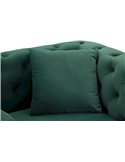 Coussin carré vert posé contre le dossier capitonné du fauteuil