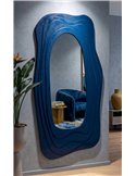 Miroir mural organique bleu accroché dans un salon avec fauteuil