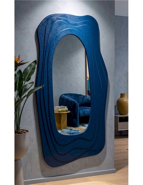 Miroir mural organique bleu accroché dans un salon avec fauteuil