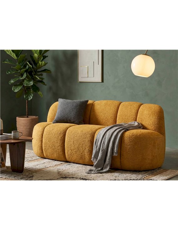Canapé 2 places aux volumes arrondis jaune, mise en scène avec coussin gris