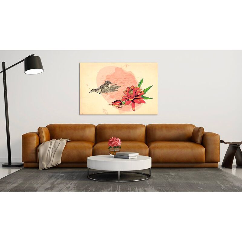 Tableau premier vol accroché au-dessus d'un canapé en cuir camel dans un salon