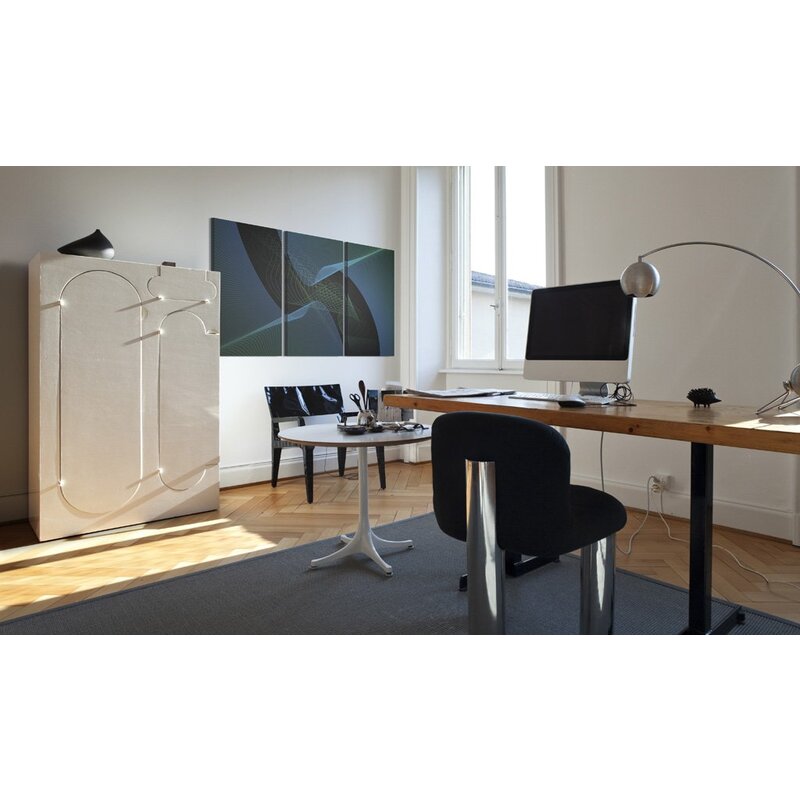 Tableau espace bleu accroché au-dessus d'un bureau dans une pièce lumineuse