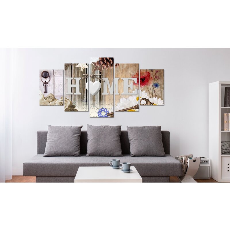 Tableau gamme de maison de variété accroché au-dessus d'un canapé gris