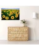 Tableau champ de tournesols au-dessus d'un meuble bas avec lettrage en bois