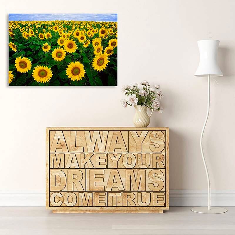Tableau champ de tournesols au-dessus d'un meuble bas avec lettrage en bois