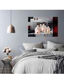 Tableau orchidée blanche accroché au-dessus d'un lit dans une chambre aux tons gris