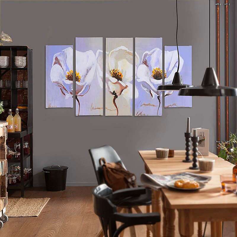 Tableau trois fleurs accroché au mur d'une salle à manger, au-dessus d'une table en bois