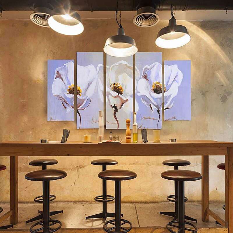Tableau trois fleurs au-dessus d'un bar, entouré de suspensions noires et de tabourets