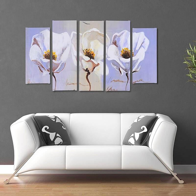 Tableau trois fleurs accroché au-dessus d'un canapé blanc, dans un salon au mur gris