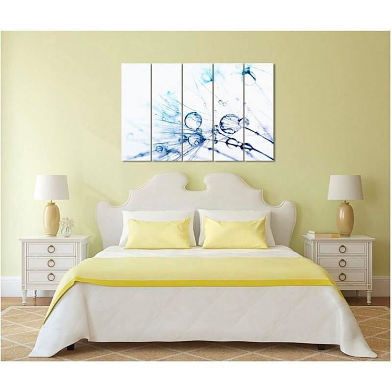 Tableau des gouttes d'eau accroché au mur au-dessus d'un lit, avec chevets et linge jaune
