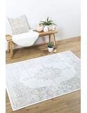 Tapis Isphahan posé sur parquet, à côté d'un banc en bois et d'objets déco