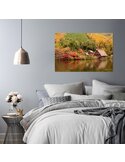 Tableau le paysage côtier accroché au-dessus d'un lit, chambre aux draps gris et lampe suspendue