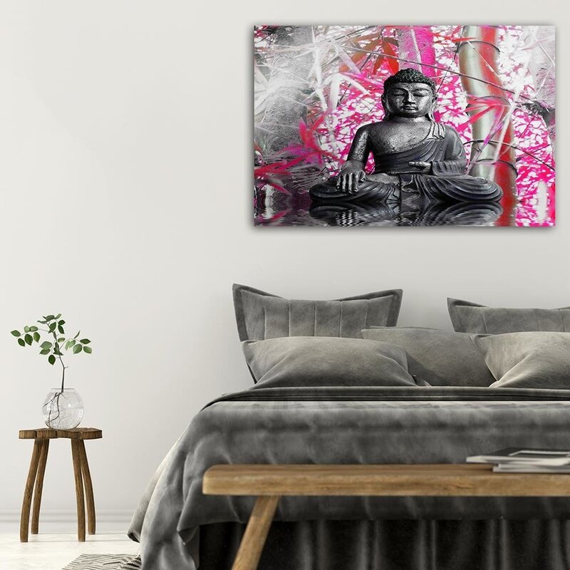 Tableau bouddha et bambou accroché au-dessus d'un lit gris dans une chambre
