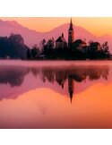 Tableau château sur un lac de montagne en gros plan, clocher et reflet au lever du soleil
