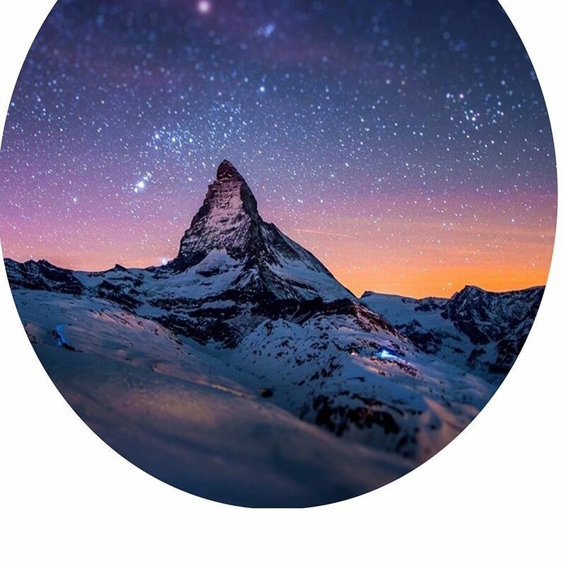 Tableau haut et ciel étoilé en gros plan sur le disque de ciel et le sommet enneigé