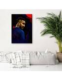 Tableau portrait de footballeur accroché au mur d'un salon, plante verte et canapé