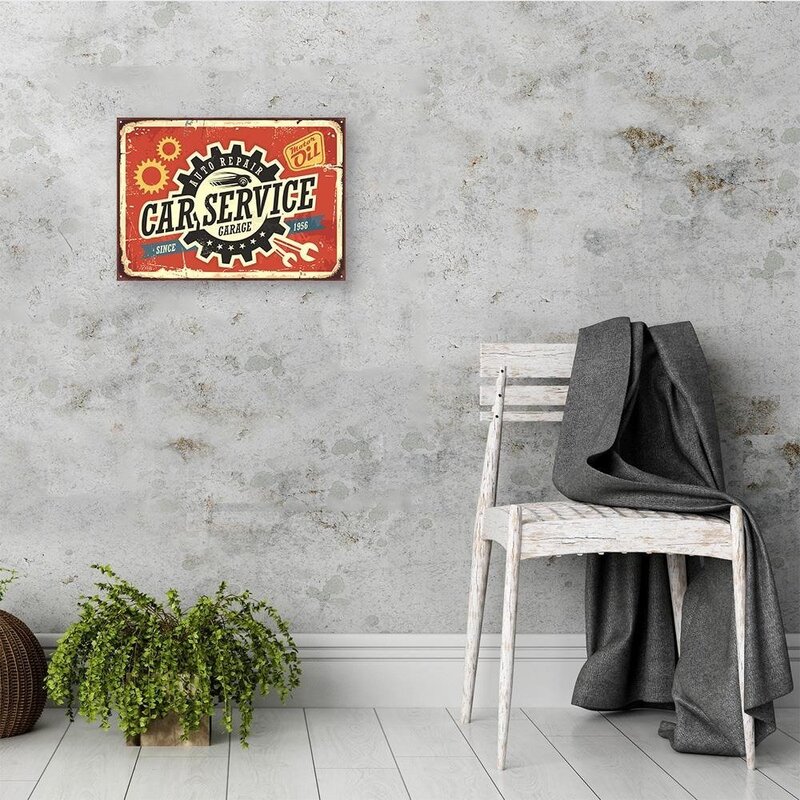 Tableau retro service de voiture accroché dans une pièce avec chaise et plante