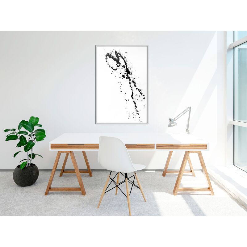 Tableau Éclaboussures d'encre accroché au mur blanc au-dessus d'un bureau