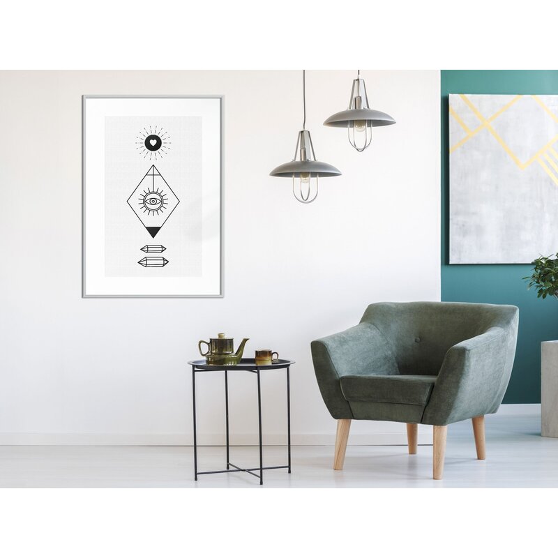 Tableau cadre Intuition accroché dans un salon, avec fauteuil vert et lampes suspendues autour