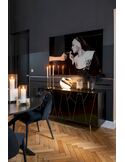 Chaise Gentry noire placée près d'une table ronde et d'un buffet laqué dans une pièce sombre