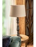 Vue en contre-plongée de la lampe grise sur une table ronde en bois clair