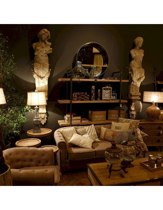 Lampe de salon dans un intérieur, entourée de statues, canapé et étagères