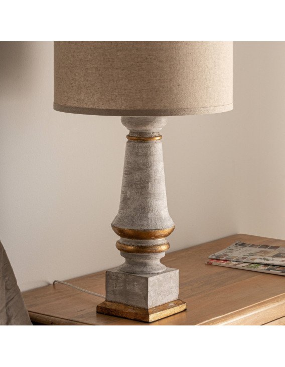 Lampe de salon posée sur une commode en bois, vue rapprochée du pied